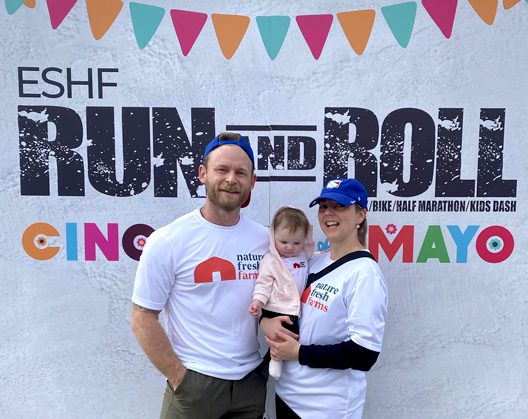 A family posing at the ESHF Run and Roll event, wearing Nature Fresh Farms t-shirts.